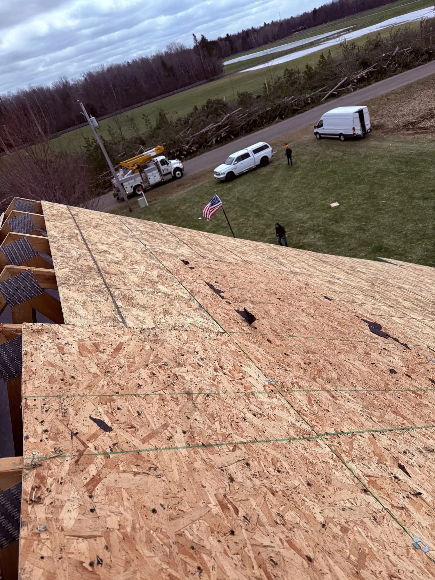 Looking down from a fresh roof deck onto Shield trucks and the residential job site.