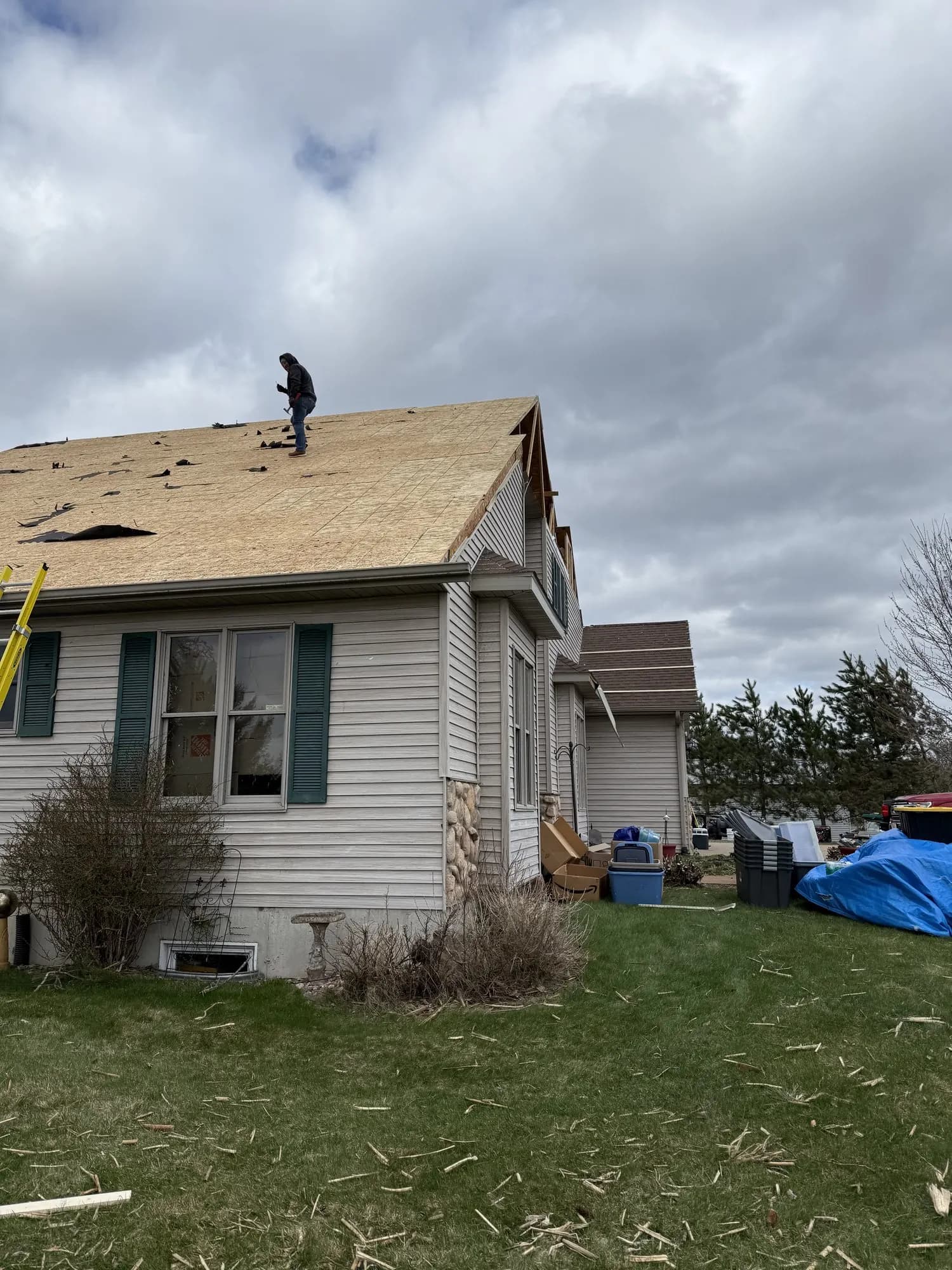 Shield Restoration worker on a residential roof after storm damage.