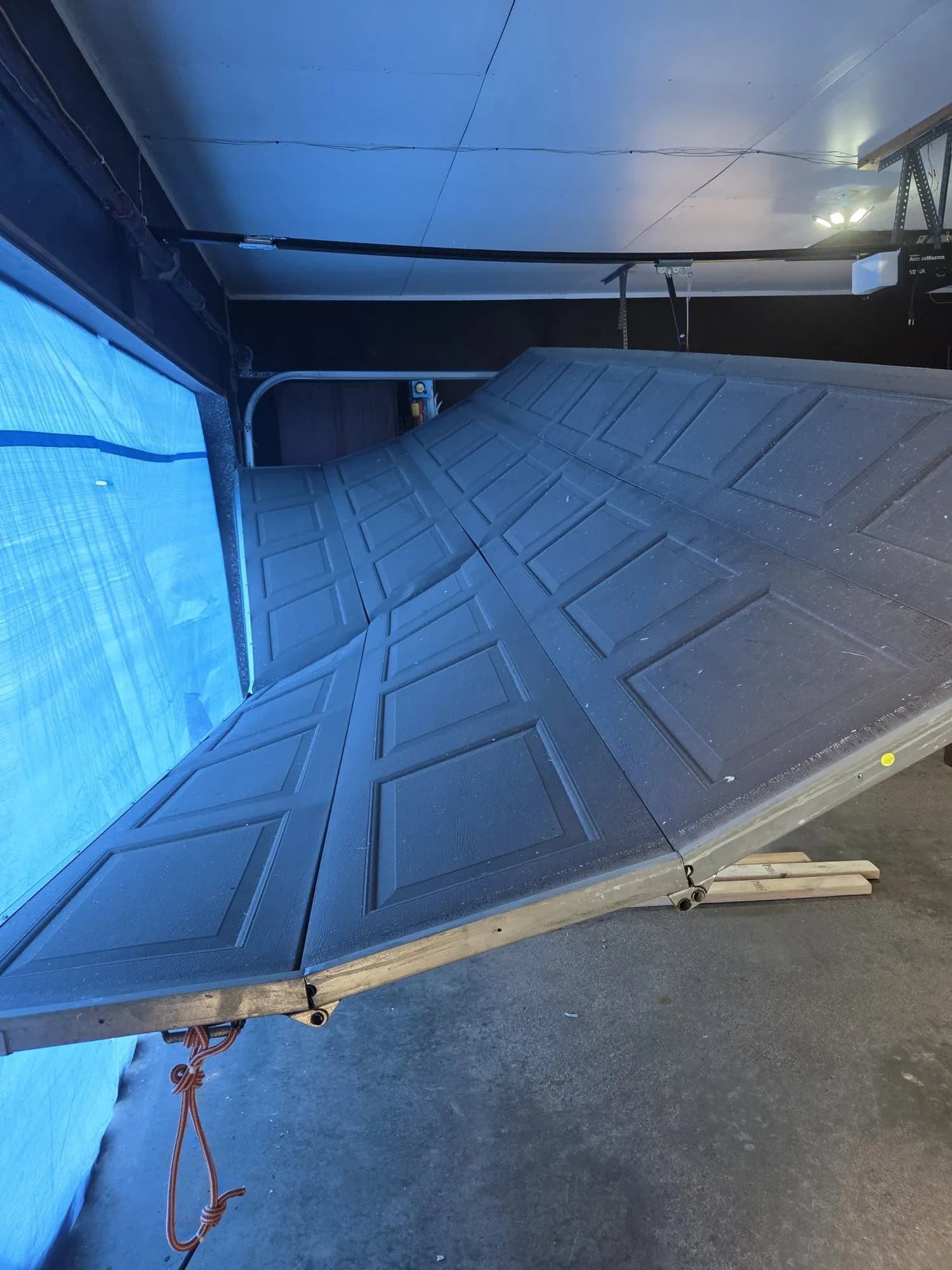 Storm-damaged garage door knocked off its track.
